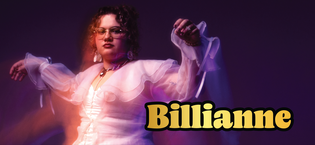 A woman with curly hair, glasses, and ruffled sheer sleeves poses confidently against a purple background. The bold yellow text Billianne is displayed in the lower right corner.